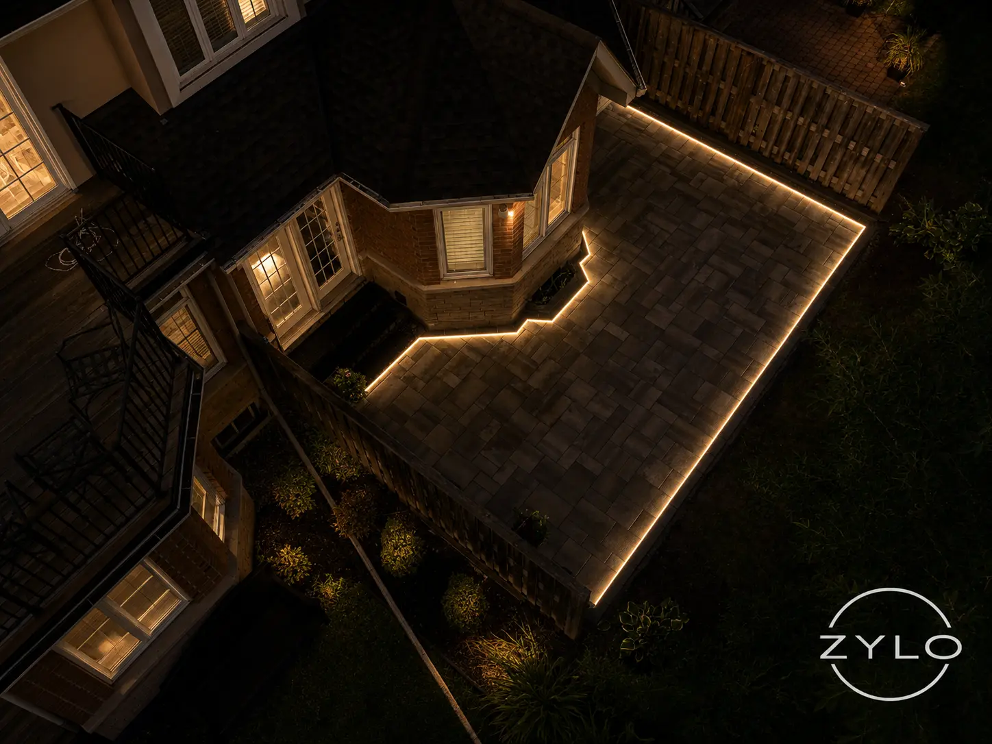 Backyard patio perimeter outlined with Zylo LED lighting